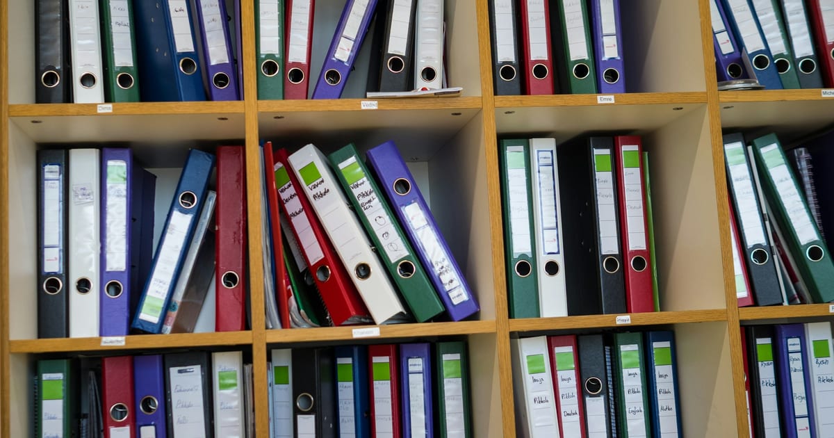 Shelves filled with rows of ring binders in different colours.