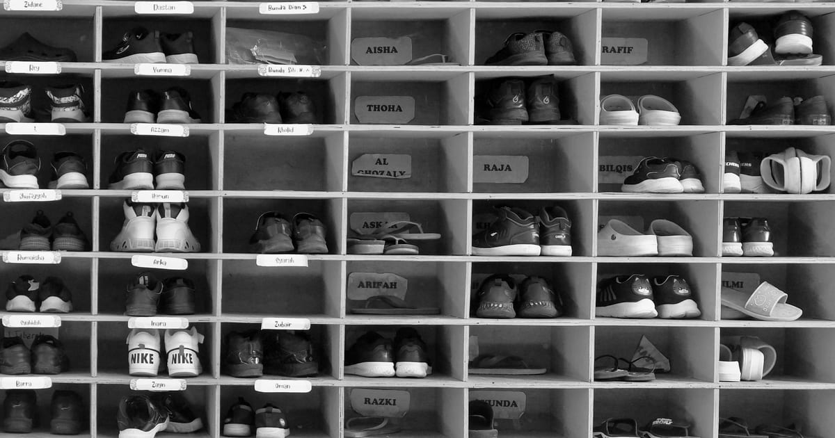 A tall shelving unit stacked with rows of shoes.